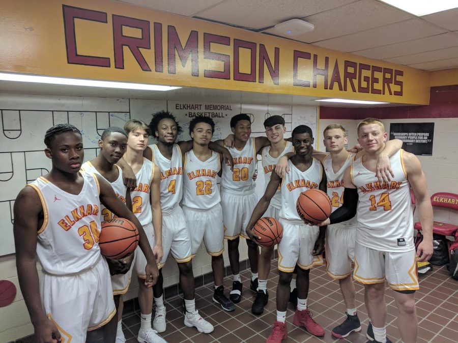 The boys basketball team poses for a photo in the Chargers locker room. The Chargers went 16-6 this season, but unfortunately lost in the first round of sectionals.