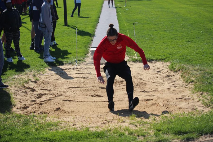 Senior Brian Ketcham is long jumping and sticks the landing on April 26th, 2019.