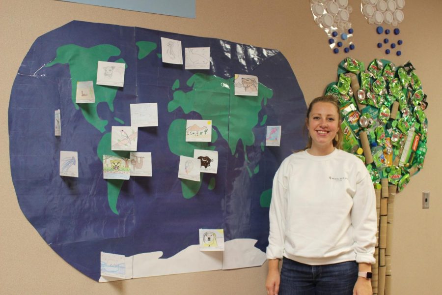 Environmental Science teacher, Jenny Summers, shares a student project that is displayed outside her classroom on Friday, Oct. 11. Summers explains why the fires were set and what the effect will be.