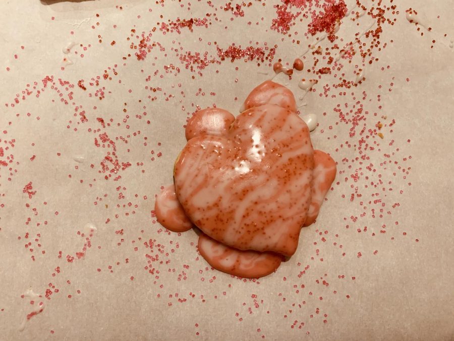 This heart shaped sugar cookie covered with icing and surrounded by sprinkles is a true depiction of what can be found on the Netflix show, Nailed It!