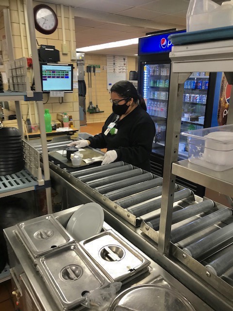 Junior Jessica Meza prepares a tray during her shift as a food carrier at the hospital on Saturday, May 23. Meza continued to work during the stay at home order to help her family make ends meet. Photo by Caleb Webb