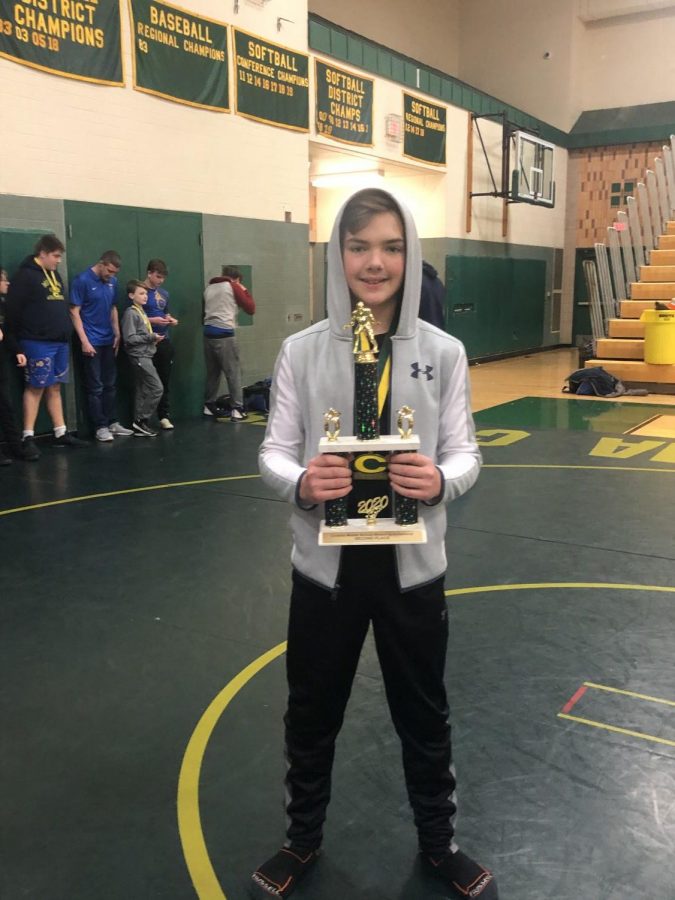 Cade Tyrakowski, son to Jeff Miller and Julie Tyrakowski, poses with his wrestling trophy. Cade has made Elkhart Memorial a second home due to the dedication and time his parents put into the high school, but the family still makes time for his extracurriculars as well.