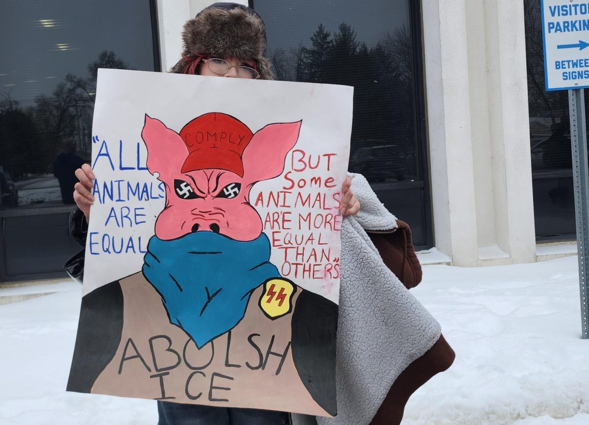 A Student holds up a protest sign.
