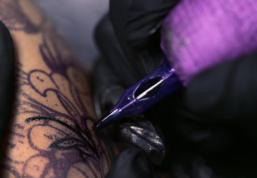 A tattoo needle is in the process of completing a design.